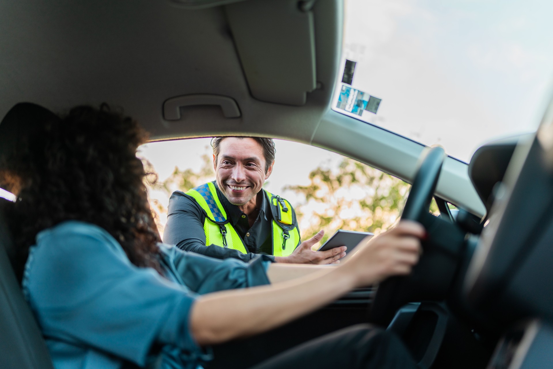 Young woman talking to traffic cop inside car