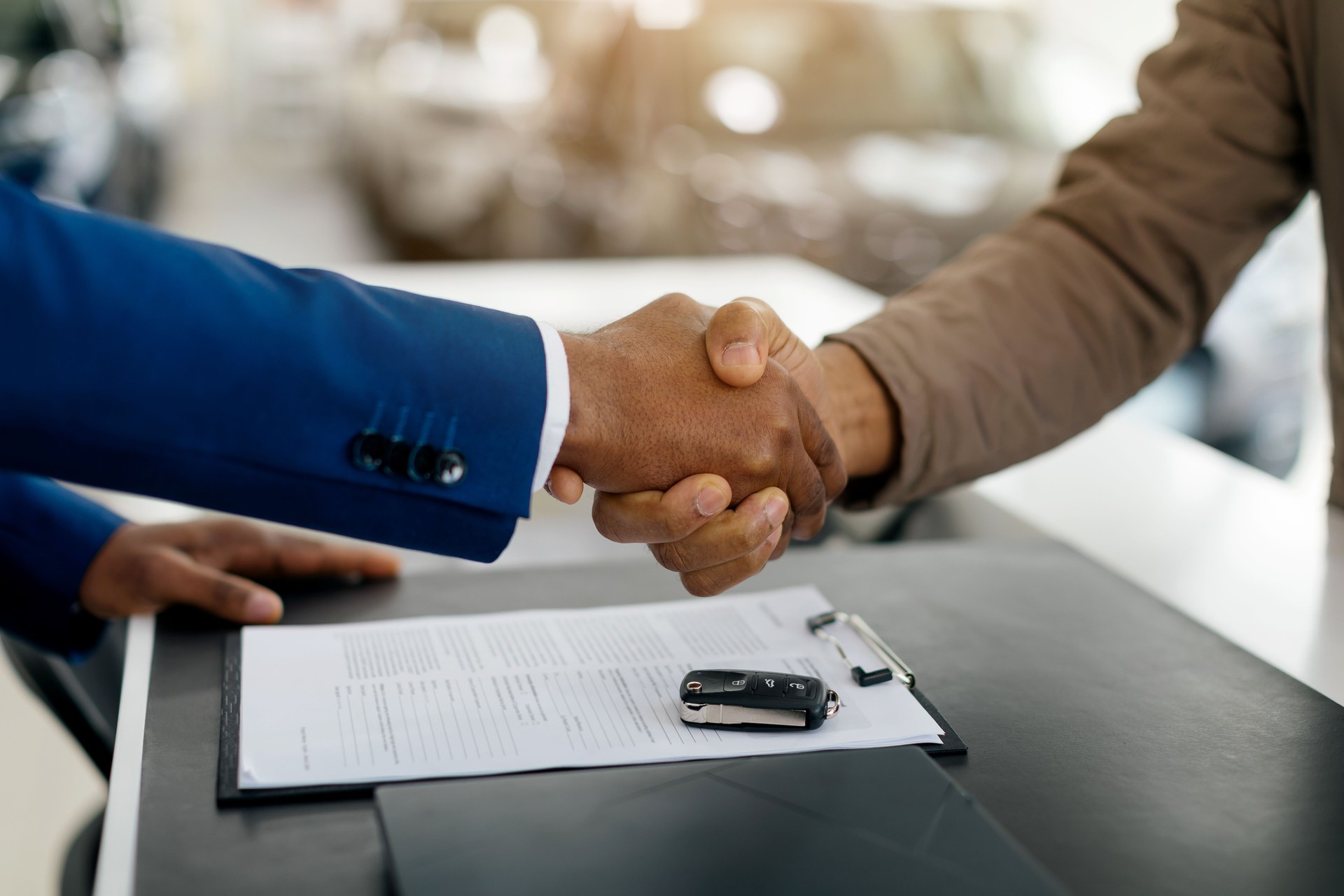Car Buyer And Auto Seller Shaking Hands Buying Automobile In Luxury Dealership Store. Closeup, Cropped, Free Space